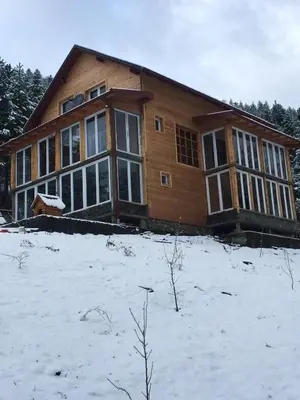 a house on a snow covered hill with at Spacious and Charming House in Vozuća with Large Garden in Vozuća