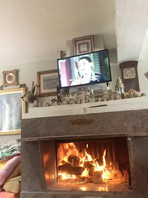a living room with a fireplace with a flat screen tv at Spacious and Charming House in Vozuća with Large Garden in Vozuća