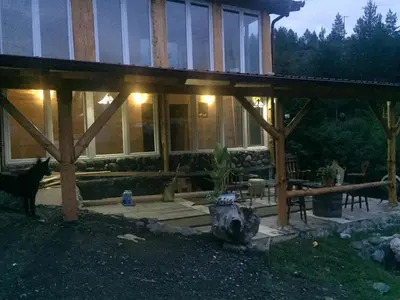 a house with a cat standing in front of it at Spacious and Charming House in Vozuća with Large Garden in Vozuća