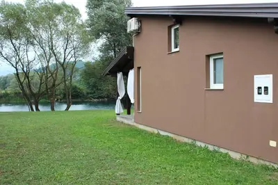 a house with a grass yard next to a river at House Legacy in Bihać