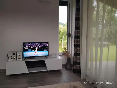 a living room with a tv and a window at House Legacy in Bihać