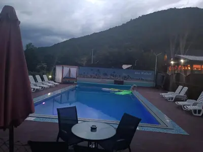 a swimming pool with chairs and a table next to it at Live Nature in Bihać