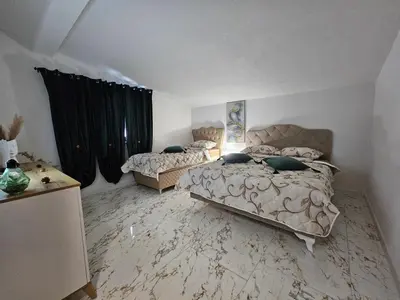 a bedroom with a bed and a table and curtains at Villa Adanis in Bihać