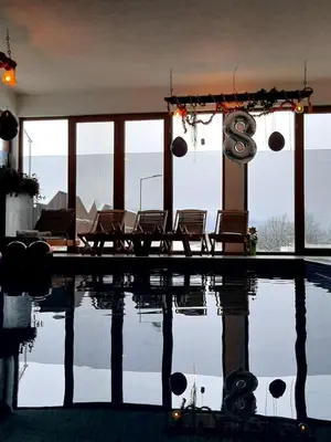 a swimming pool with chairs in a house at Villa Adanis in Bihać