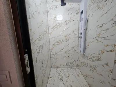 a bathroom with a marble shower stall with a door at Villa Adanis in Bihać