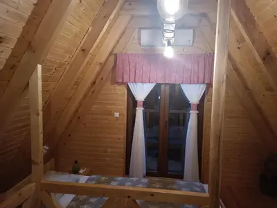 a window in the attic of a log cabin at Villa Adanis in Bihać