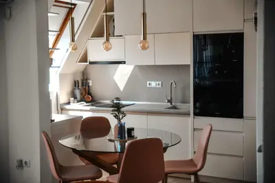 a small kitchen with a glass table and chairs at Apartments Centar in Živinice