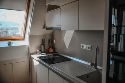 a kitchen with white cabinets and a sink and a window at Apartments Centar in Živinice