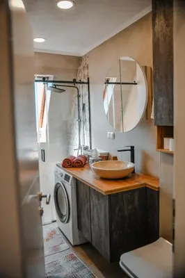 a bathroom with a sink and a washing machine at Apartments Centar in Živinice
