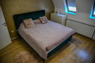 a bedroom with a bed with two pillows on it at Apartments Centar in Živinice