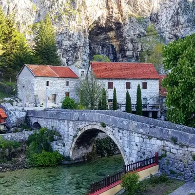 a stone bridge over a river with two buildings at Apartman Željo in Livno