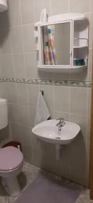 a bathroom with a sink and a toilet and a mirror at Apartman Željo in Livno