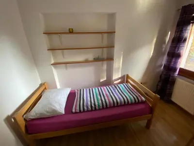 a small bed in a room with a purple cushion at Apartman Željo in Livno