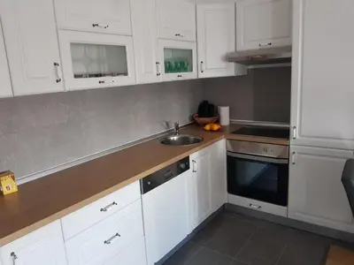 a kitchen with white cabinets and a sink at Apartman DIJANA in Banja Luka