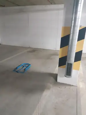 a parking garage with a blue object next to a pole at Apartman DIJANA in Banja Luka
