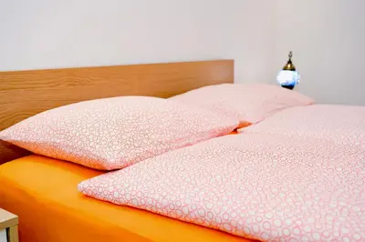 two pink pillows on top of a bed at Villa Jajce in Jajce