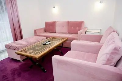 a living room with pink furniture and a table at Villa Jajce in Jajce