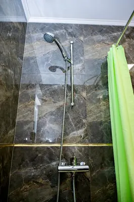 a shower in a bathroom with a green curtain at Villa Jajce in Jajce