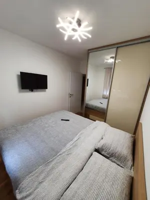a bedroom with a large bed and a mirror at Apartman Lux Doboj 2 in Doboj