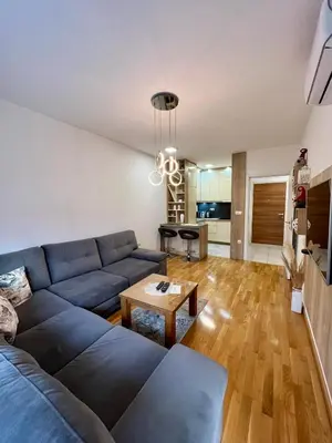 a living room with a blue couch and a table at Apartman Lux Doboj 2 in Doboj