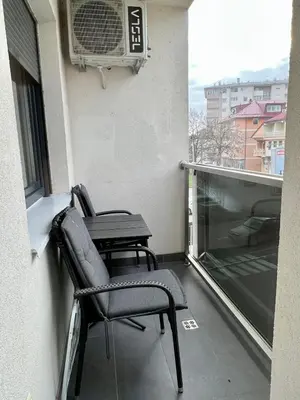 a balcony with two chairs and a table on a building at Apartman Lux Doboj 2 in Doboj