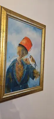 a painting of a woman with a bird in a hat at Vikendica Kod Koje in Banja Luka