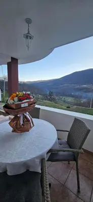 a room with a table and a chair and a view at Vikendica Kod Koje in Banja Luka