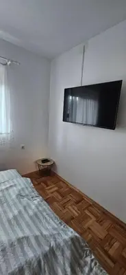 a bedroom with a bed and a flat screen tv on the wall at Vikendica Kod Koje in Banja Luka
