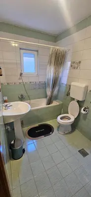 a bathroom with a sink and a toilet and a tub at Vikendica Kod Koje in Banja Luka