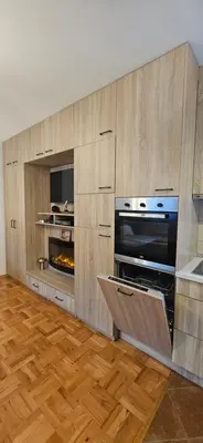 a kitchen with wooden cabinets and an oven at Vikendica Kod Koje in Banja Luka