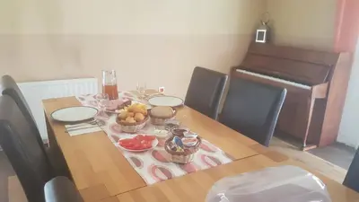 a dining room table with fruit and a piano at Apartments Crvena Jabuka in Ključ