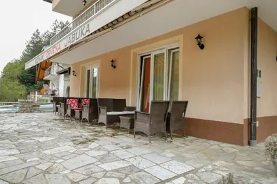 a restaurant with chairs and tables outside of a building at Apartments Crvena Jabuka in Ključ