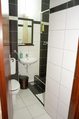 a bathroom with a toilet and a sink at Hotel TISA in Busovača