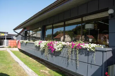 a building with flower planters on the side of it at Hotel TISA in Busovača
