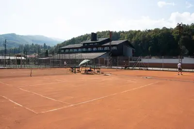 two people playing tennis on a tennis court at Hotel TISA in Busovača