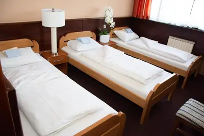 a group of three beds in a room at Hotel TISA in Busovača