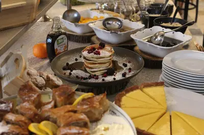 a table topped with a plate of pancakes and other food at Hotel Kostelski Buk in Bihać