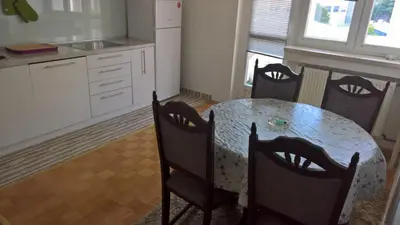a kitchen with a table and chairs in a kitchen at Apartman centar lux in Tuzla