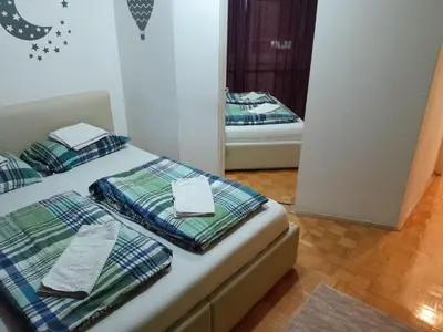 two beds in a room with a mirror at Apartman centar lux in Tuzla