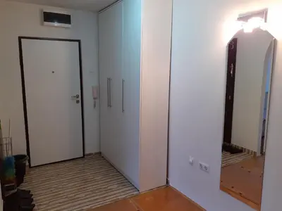 a hallway with two white doors and a mirror at Apartman centar lux in Tuzla