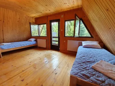 a room with two beds in a wooden cabin at Vikendica PAM in Vlasic