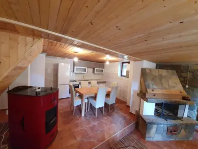 a kitchen and dining room with a table and a stove at Vikendica PAM in Vlasic