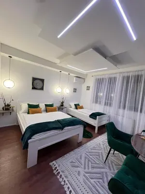 a bedroom with two beds and a couch at Aman Guesthouse in Bihać