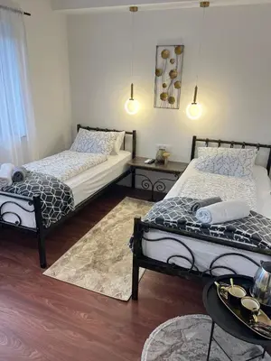 a bedroom with two beds and a table with a tray at Aman Guesthouse in Bihać
