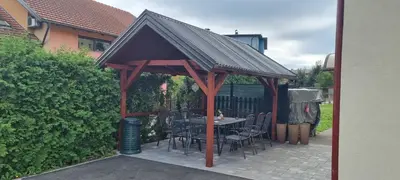 a wooden gazebo with a table and chairs at Aman Guesthouse in Bihać
