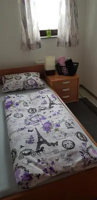 a bedroom with a bed with a comforter on it at Aman Guesthouse in Bihać