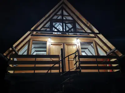 a house with a wooden door with lights on it at Lux bungalow in Foča