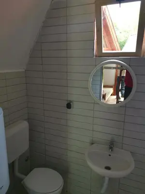 a bathroom with a sink and a toilet and a mirror at Lux bungalow in Foča