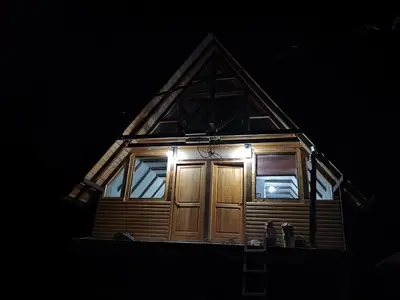 a house with a wooden door in the dark at Lux bungalow in Foča