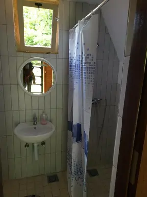 a bathroom with a sink and a shower with a mirror at Lux bungalow in Foča